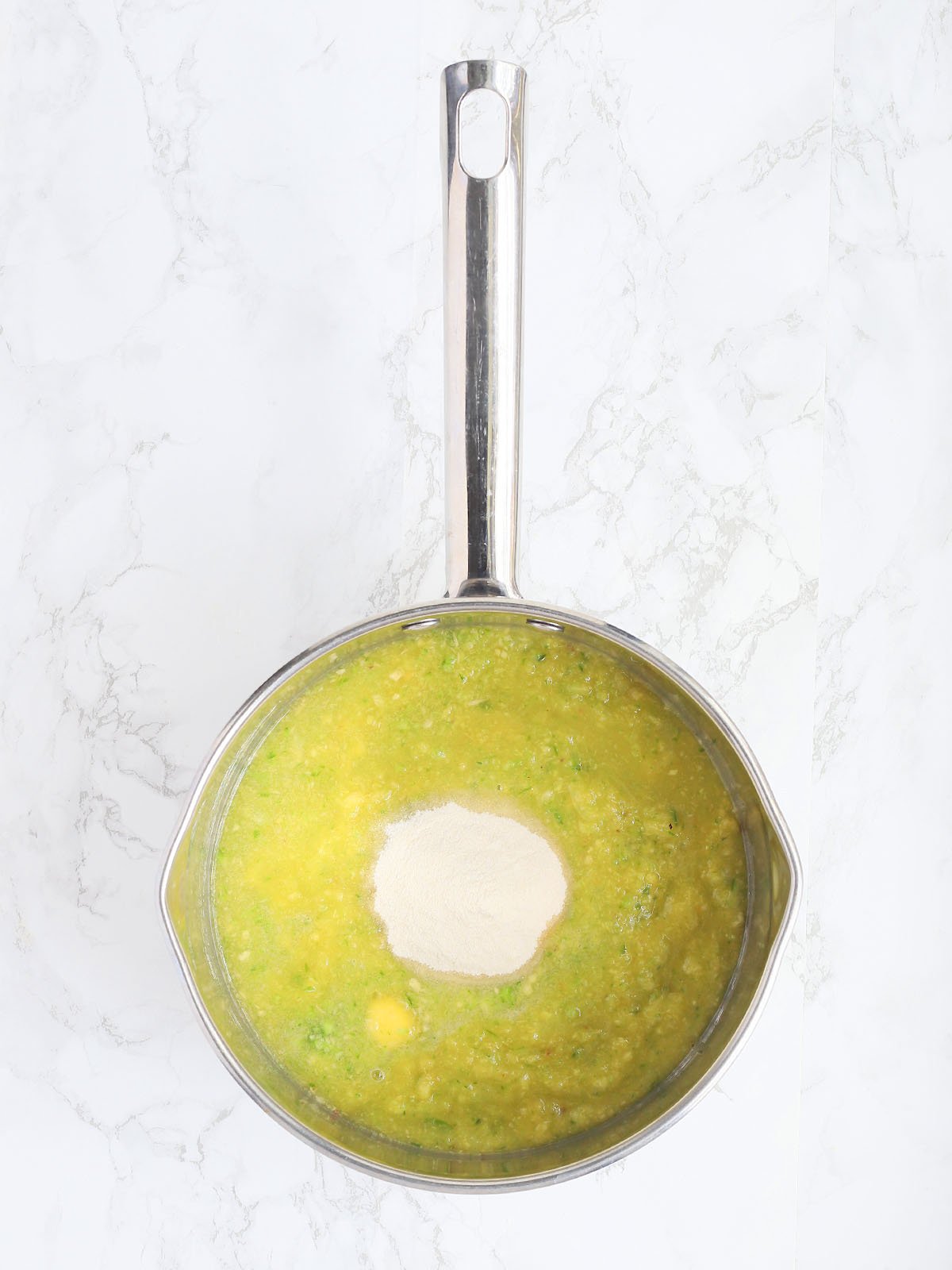 Pureed peaches, jalapeno peppers and pectin in a large stainless steel pan.