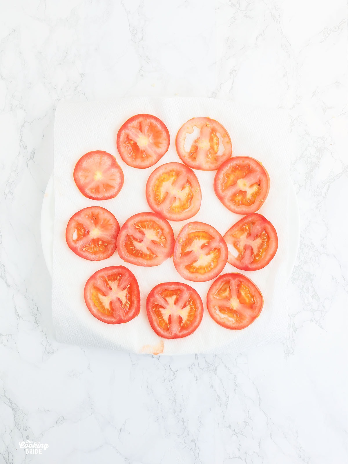 slices of fresh tomatoes drying on a layer of paper towels