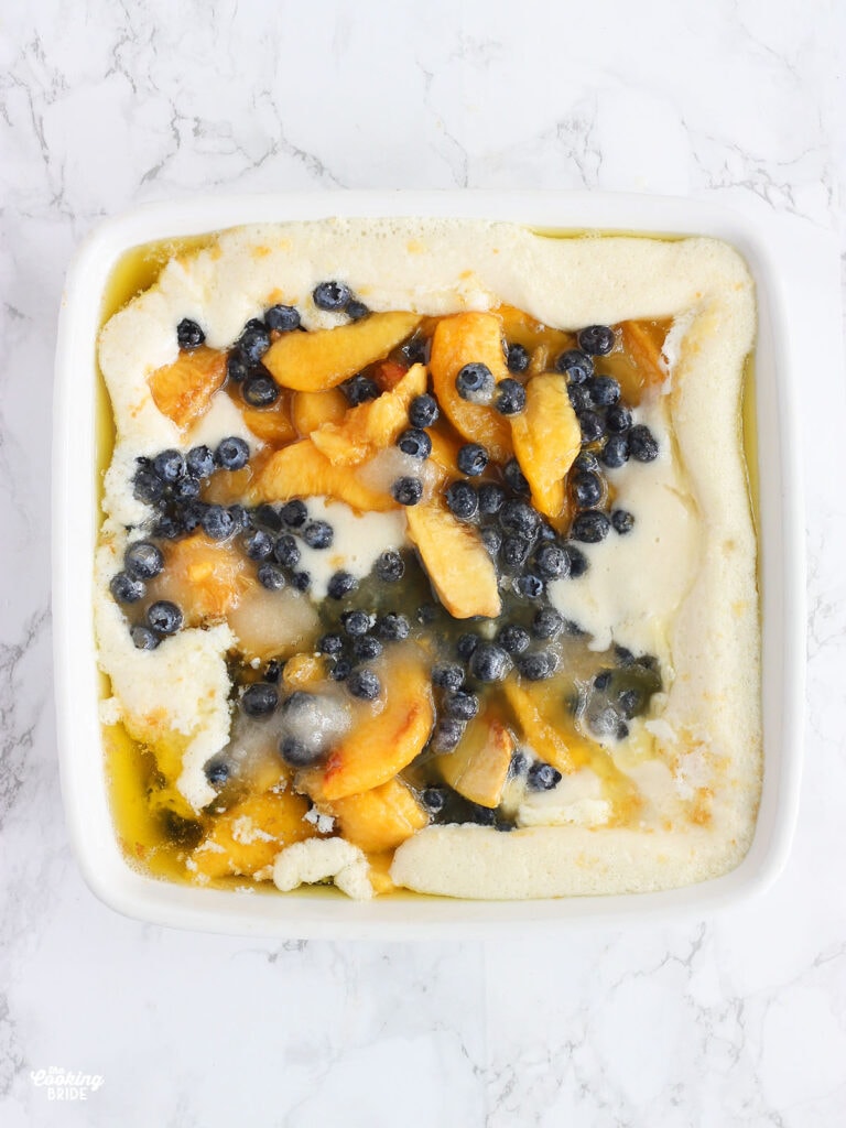 cobbler batter and fruit layered in a casserole dish