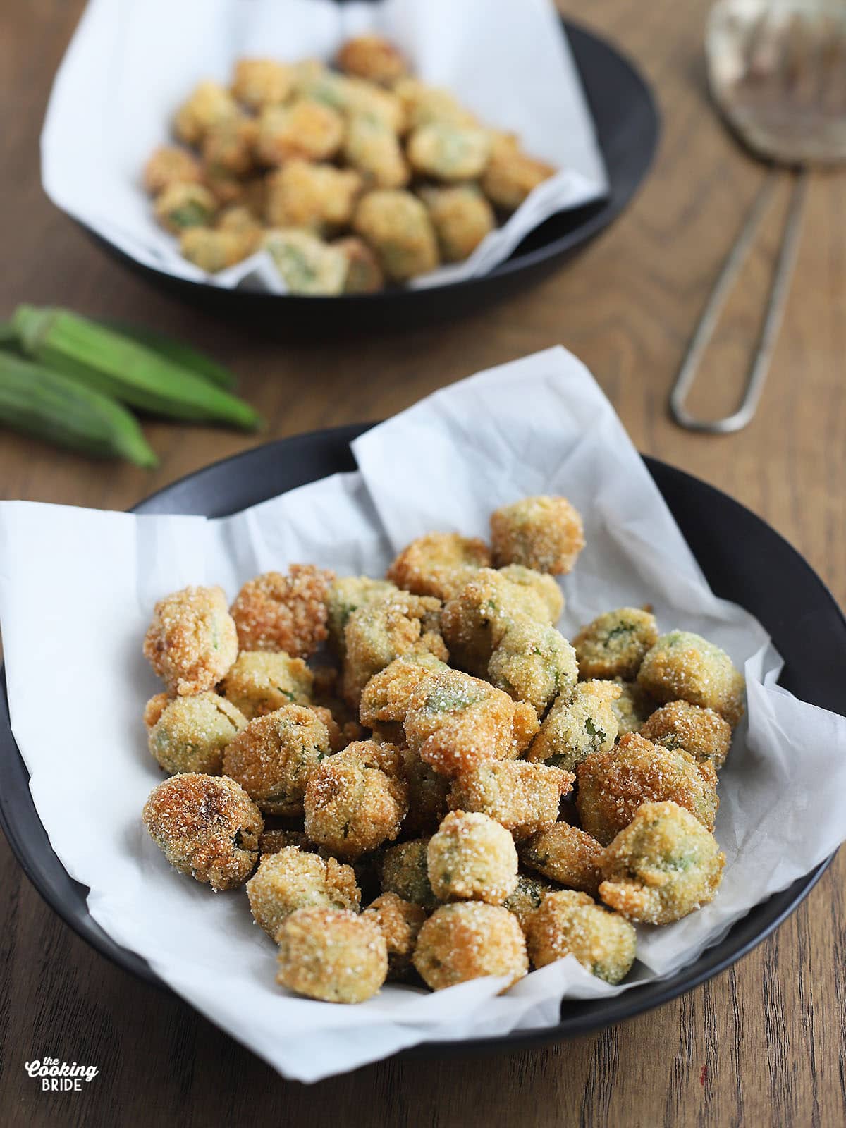 black dish of fried okra on a wooden background