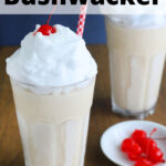 Frozen bushwacker cocktail topped with whipped cream and a cherry in a clear glass