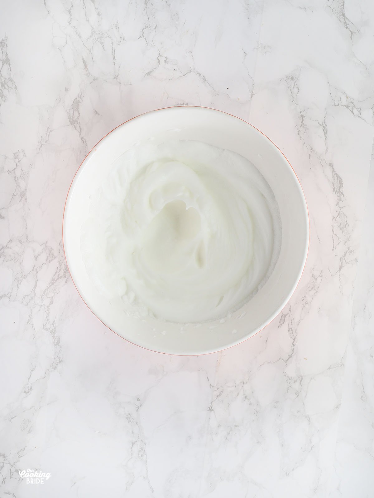 egg whites with stiff peaks in a mixing bowl