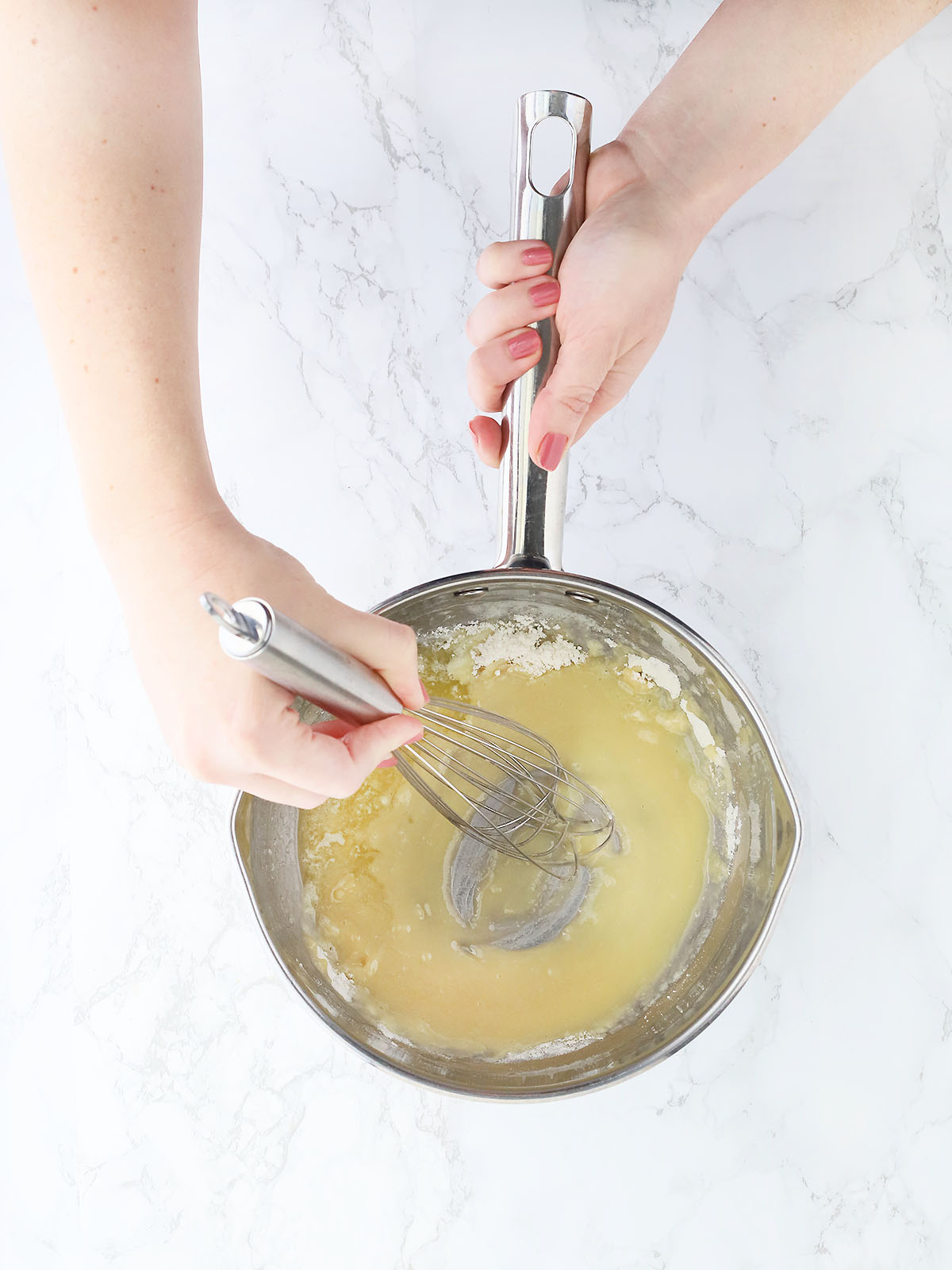 hand whisking flour into melted butter