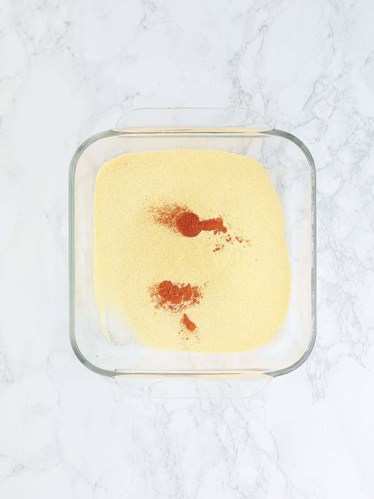 cornmeal and paprika in a glass dish