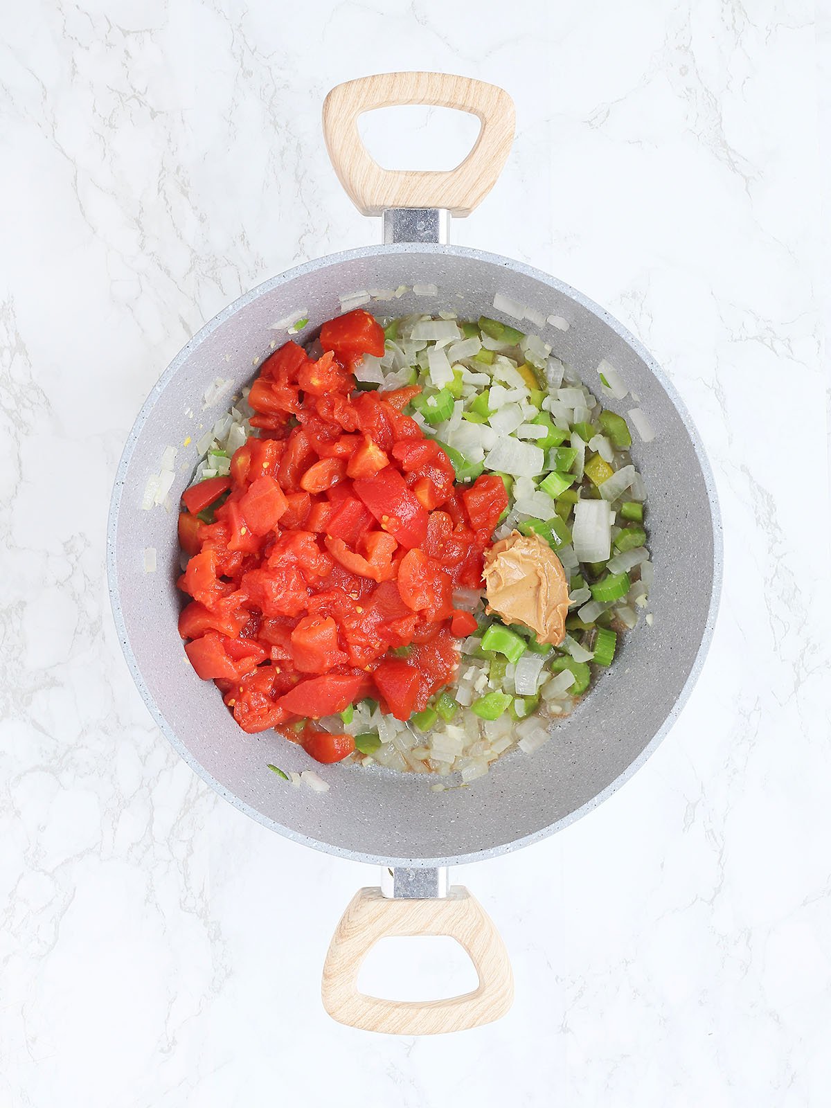 pot with diced tomatoes, diced onions, green bell peppers, and peanut butter