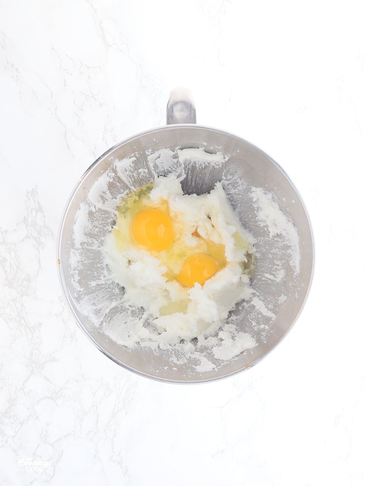 overhead shot of shortening, whole eggs and sugar in a mixing bowl