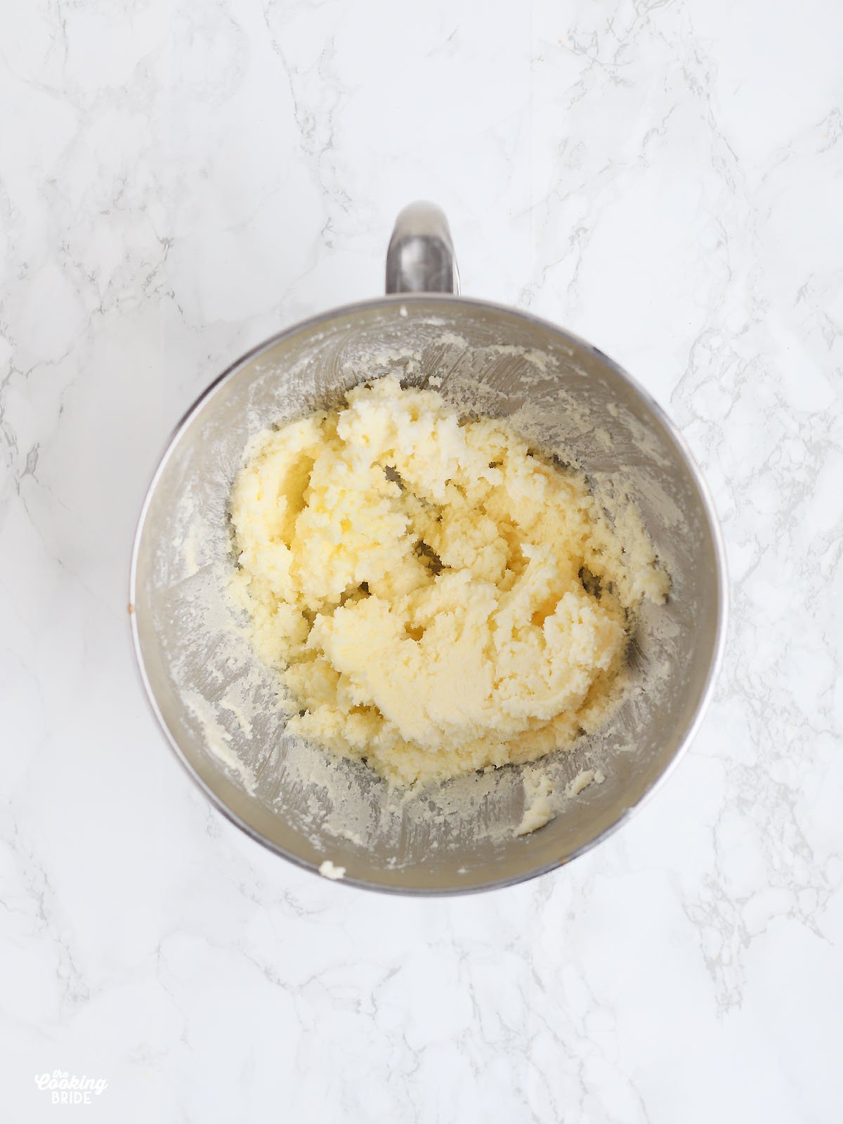 Overhead shot of butter and sugar creamed together in a metal mixing bowl