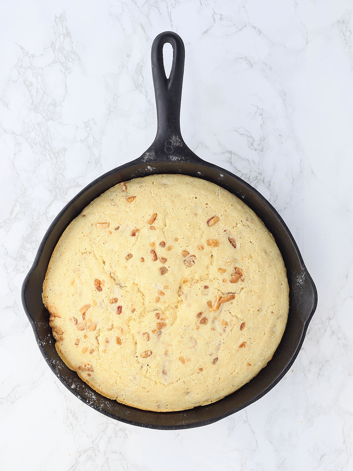 baked cracklin' corn bread in a cast iron skillet after it has come out of the oven