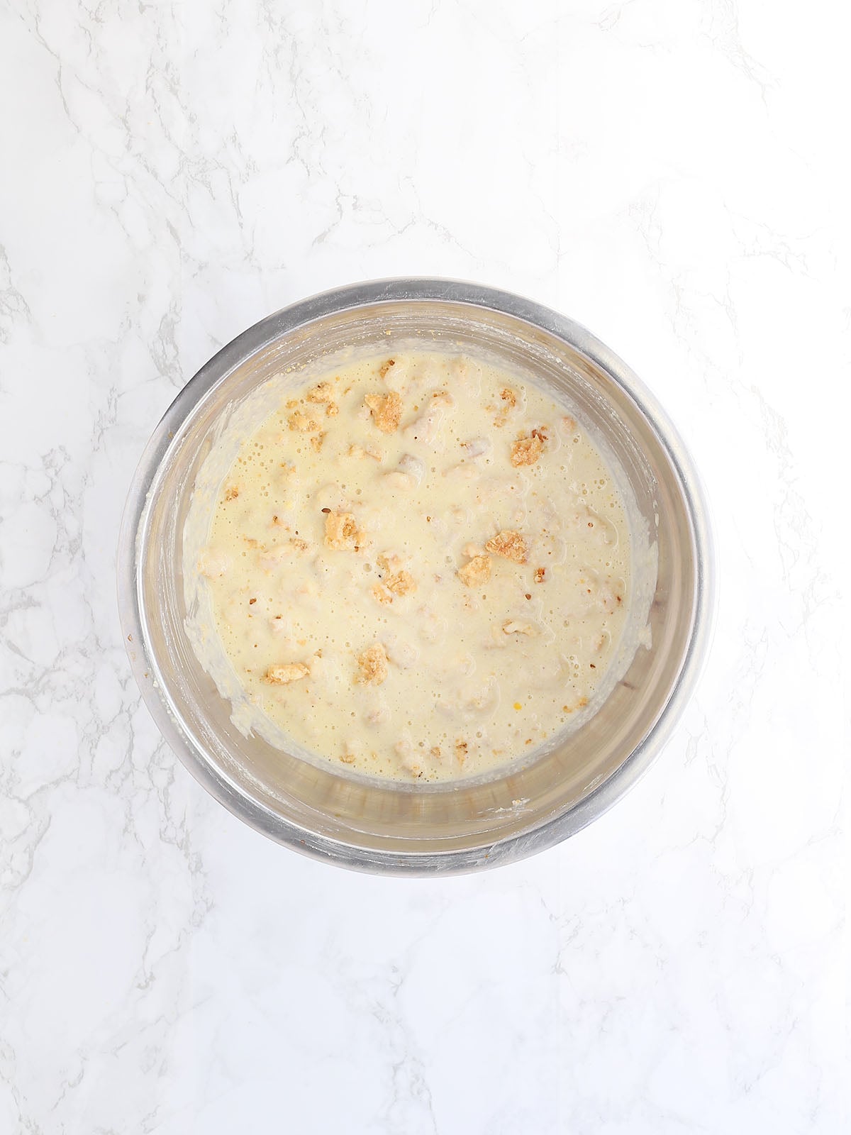 mixed cracklin corn bread batter in a stainless steel mixing bowl