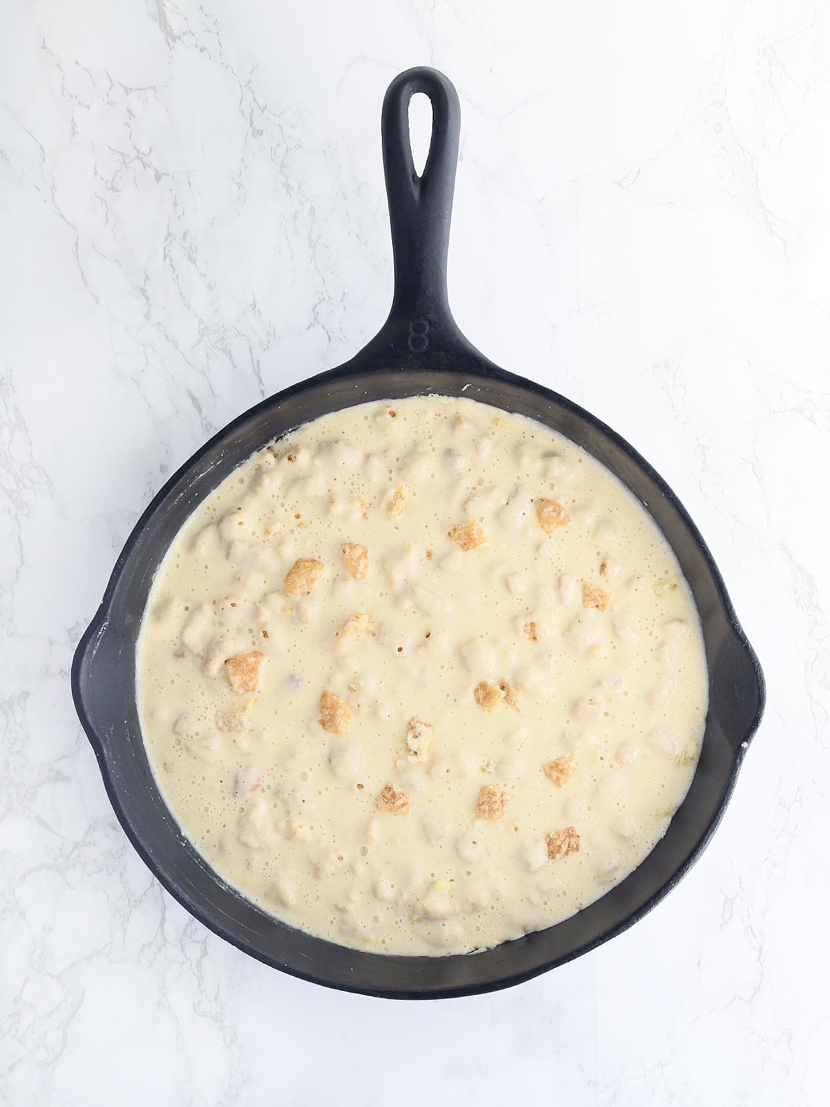 overhead shot of cracklin' corn bread batter in a cast iron skillet