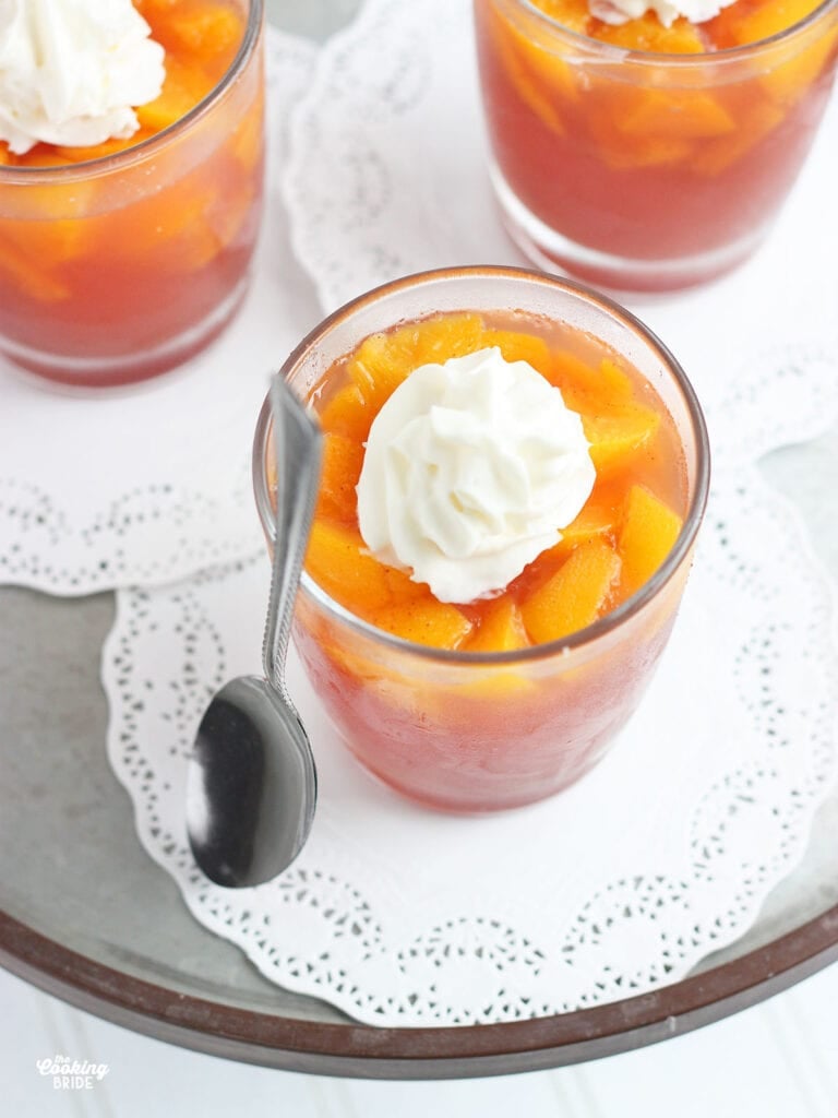 individual serving of peach jello salad topped with whipped cream