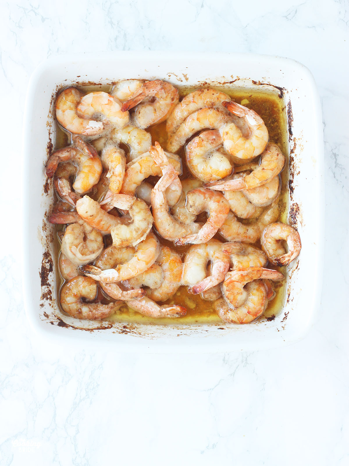 white casserole dish with cooked barbecue shrimp