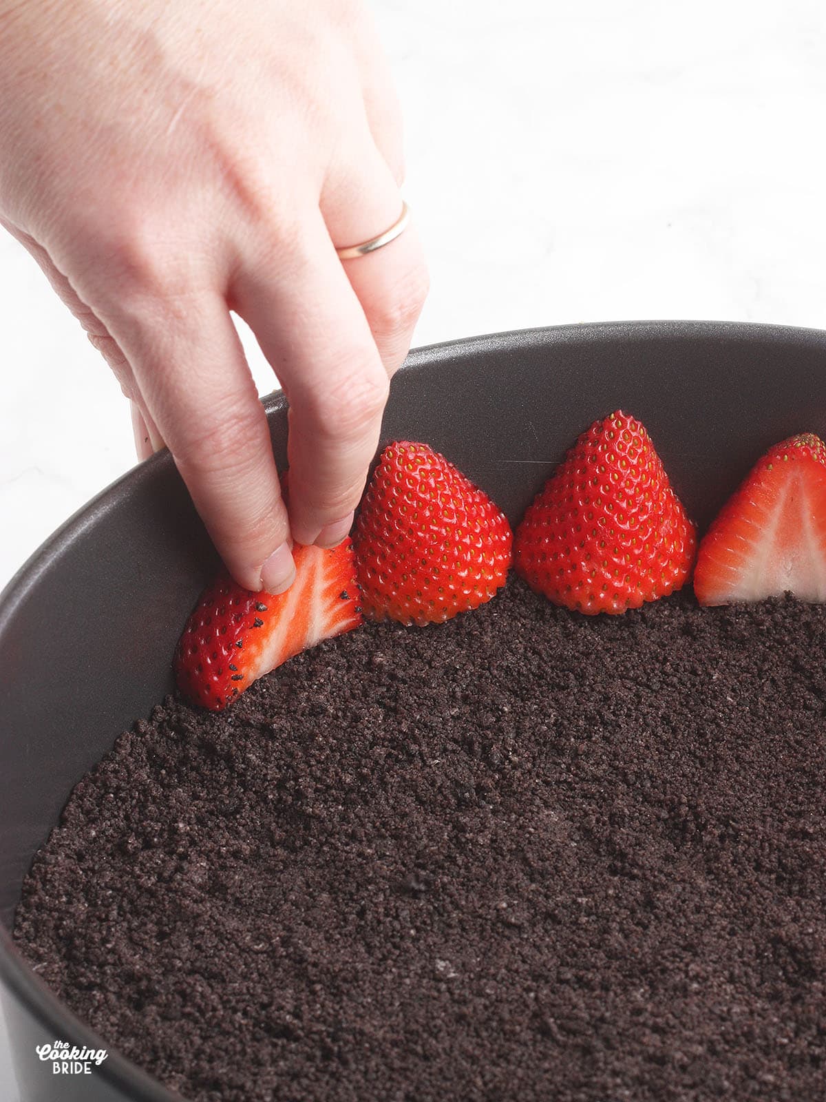 pressing strawberries against the inside of the springform pan