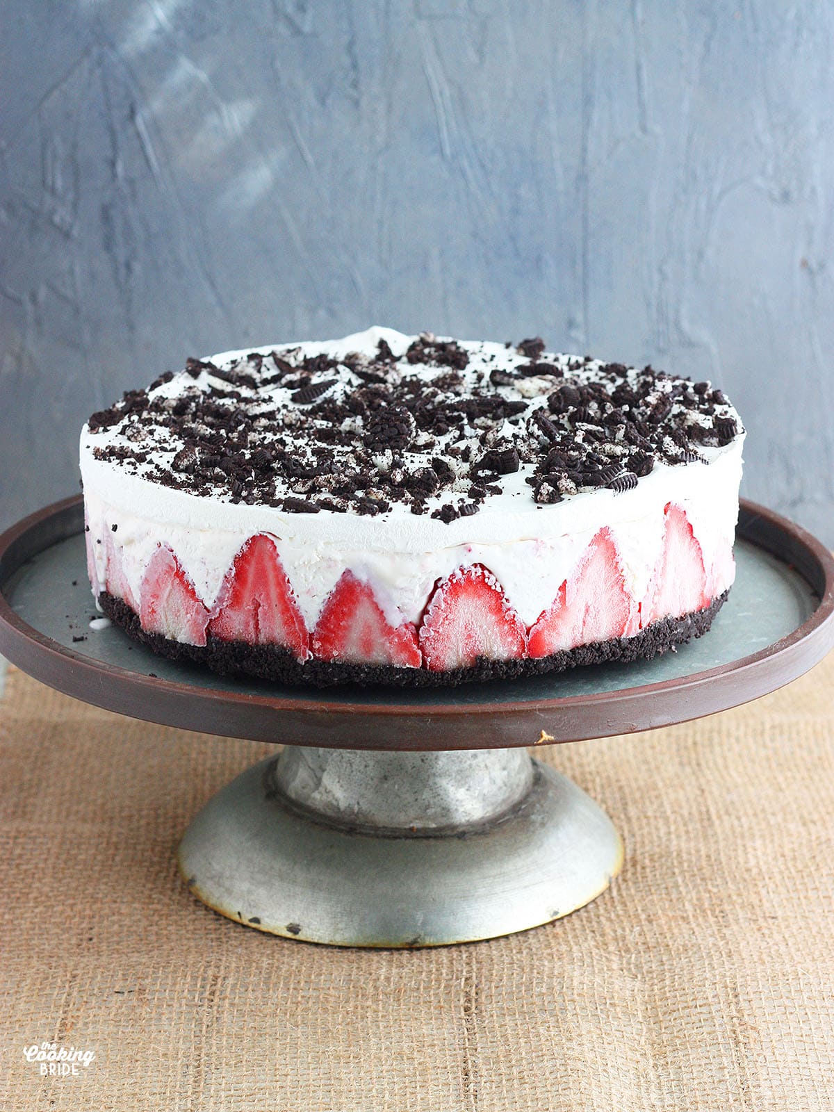 whole strawberry ice cream cake on a metal stand