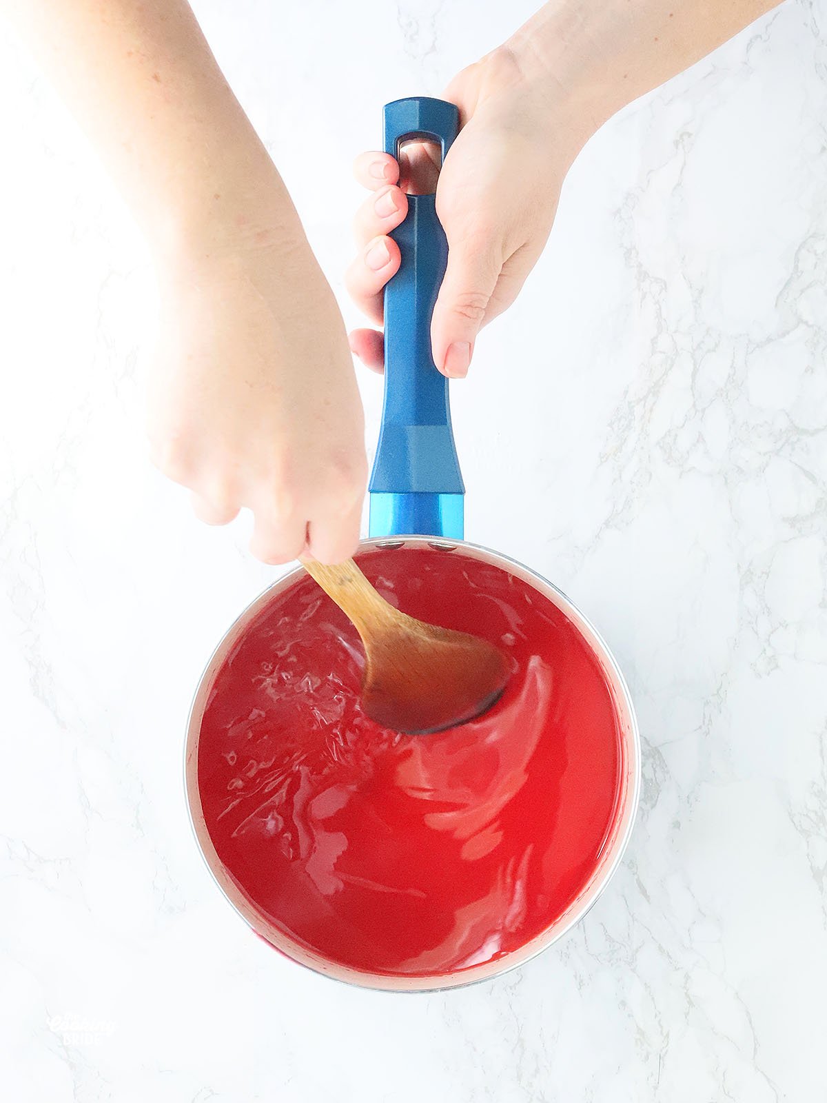 stirring strawberry gelatin into hot lemonade