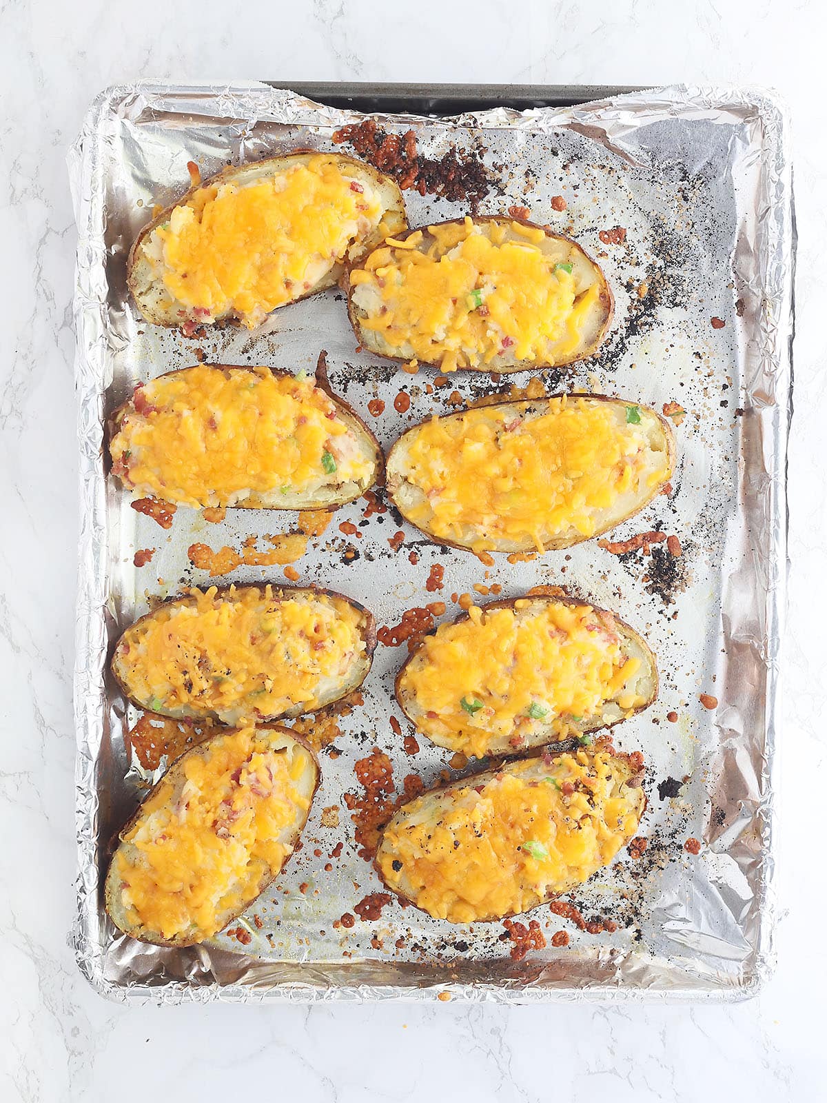 baked twice baked potatoes on a foil lined baking sheet