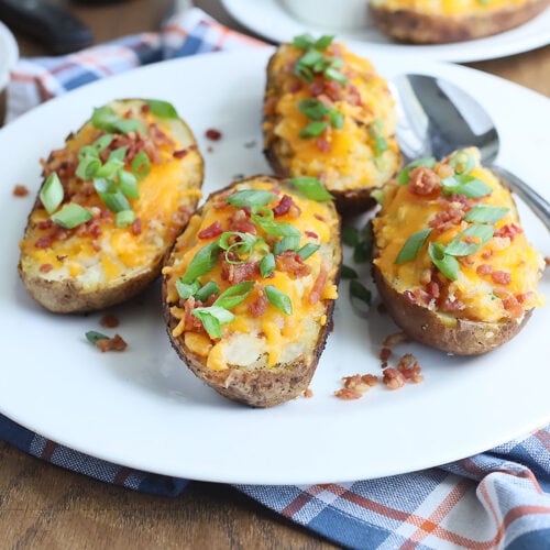 four twice baked potatoes on a white platter