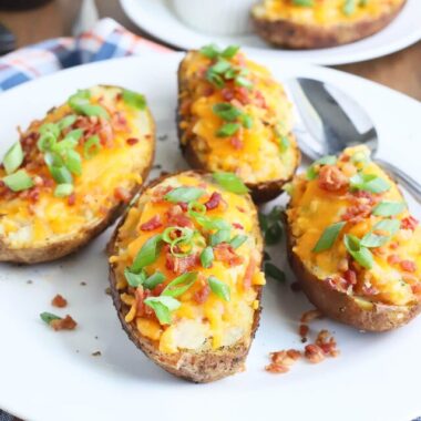four twice baked potatoes on a white platter