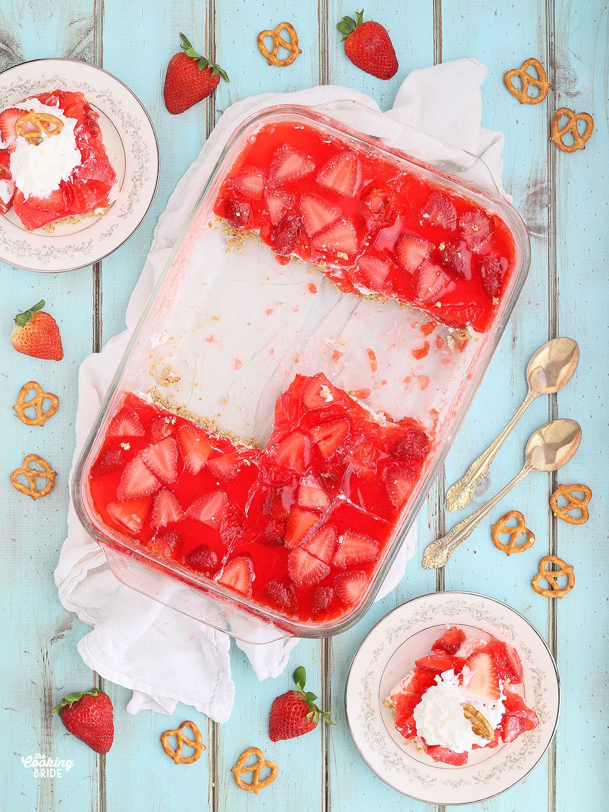 strawberry pretzel salad in a casserole dish with servings on the side