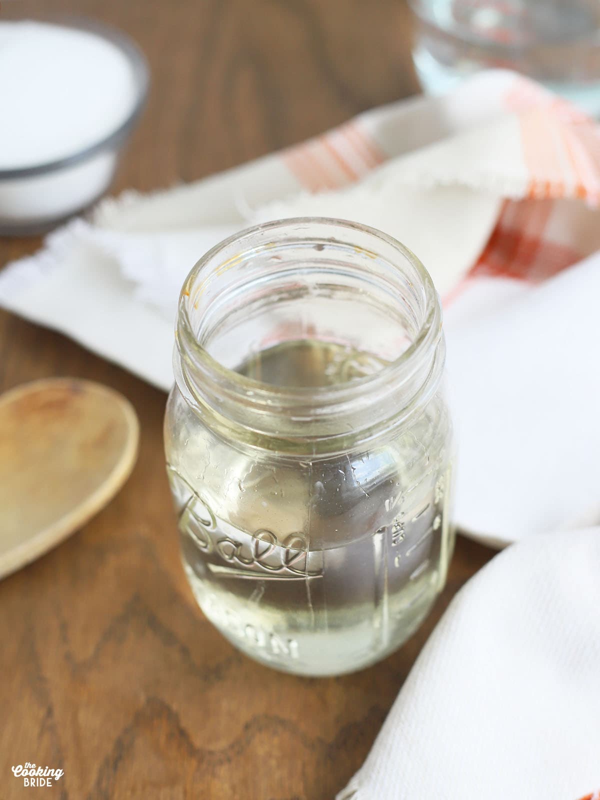 mason jar full of simple syrup with sugar and water in the background