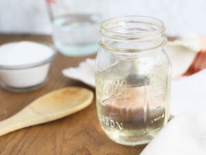 mason jar full of simple syrup with sugar and water in the background