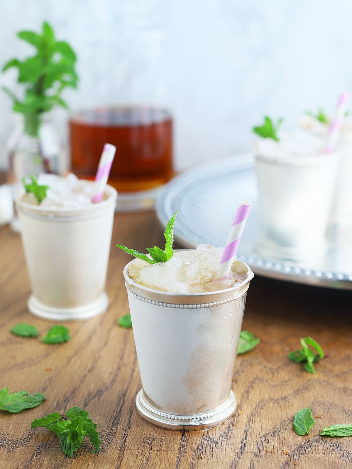 two silver mint julep cups on a wooden background
