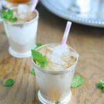 two silver mint julep cups on a wooden background