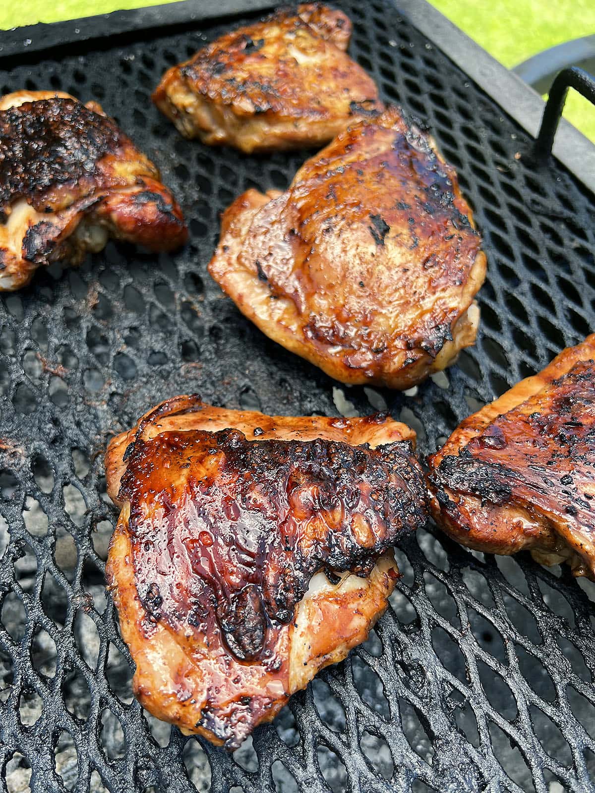 grilled pineapple chicken thighs skin side up cooking over the hot side of the grill