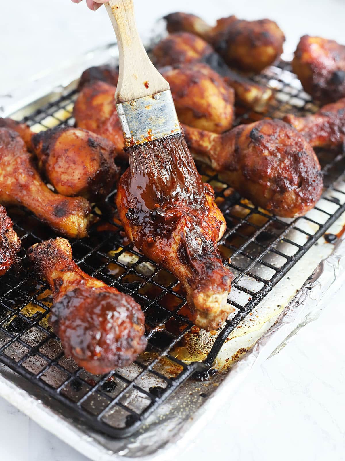 brushing the honey chipotle sauce over the drumsticks