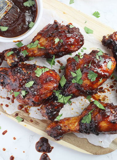 cutting board topped with chicken drumsticks coated in honey chipotle sauce