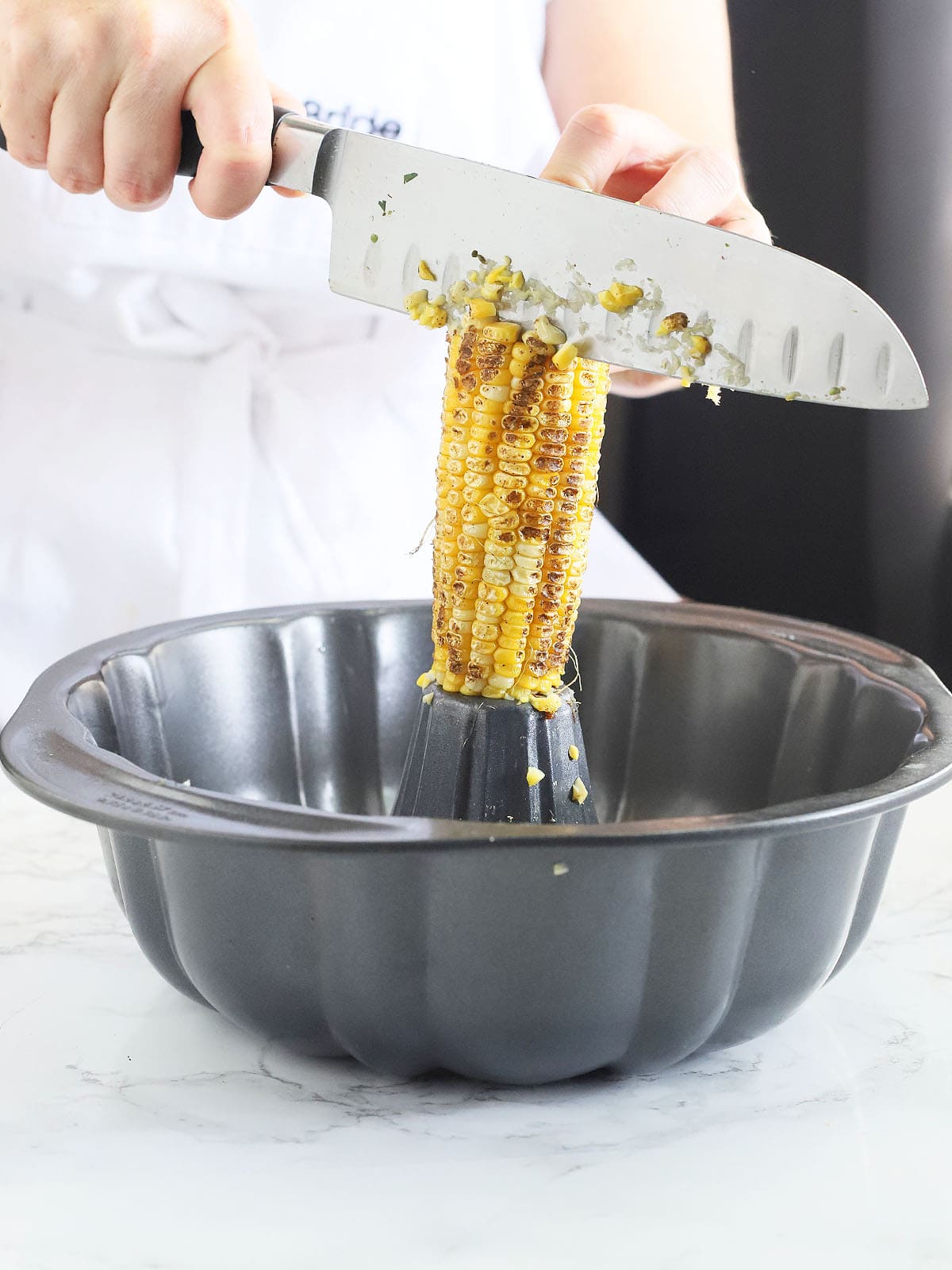 using a bundt cake pan to remove the kernels from the corn