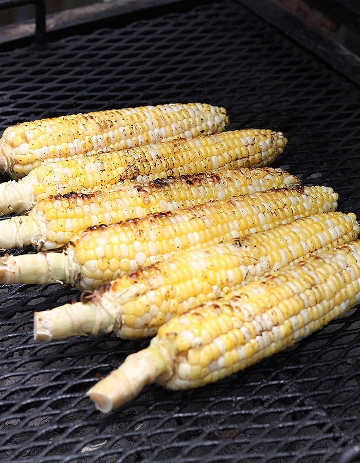 ears of corn roasting on a grill