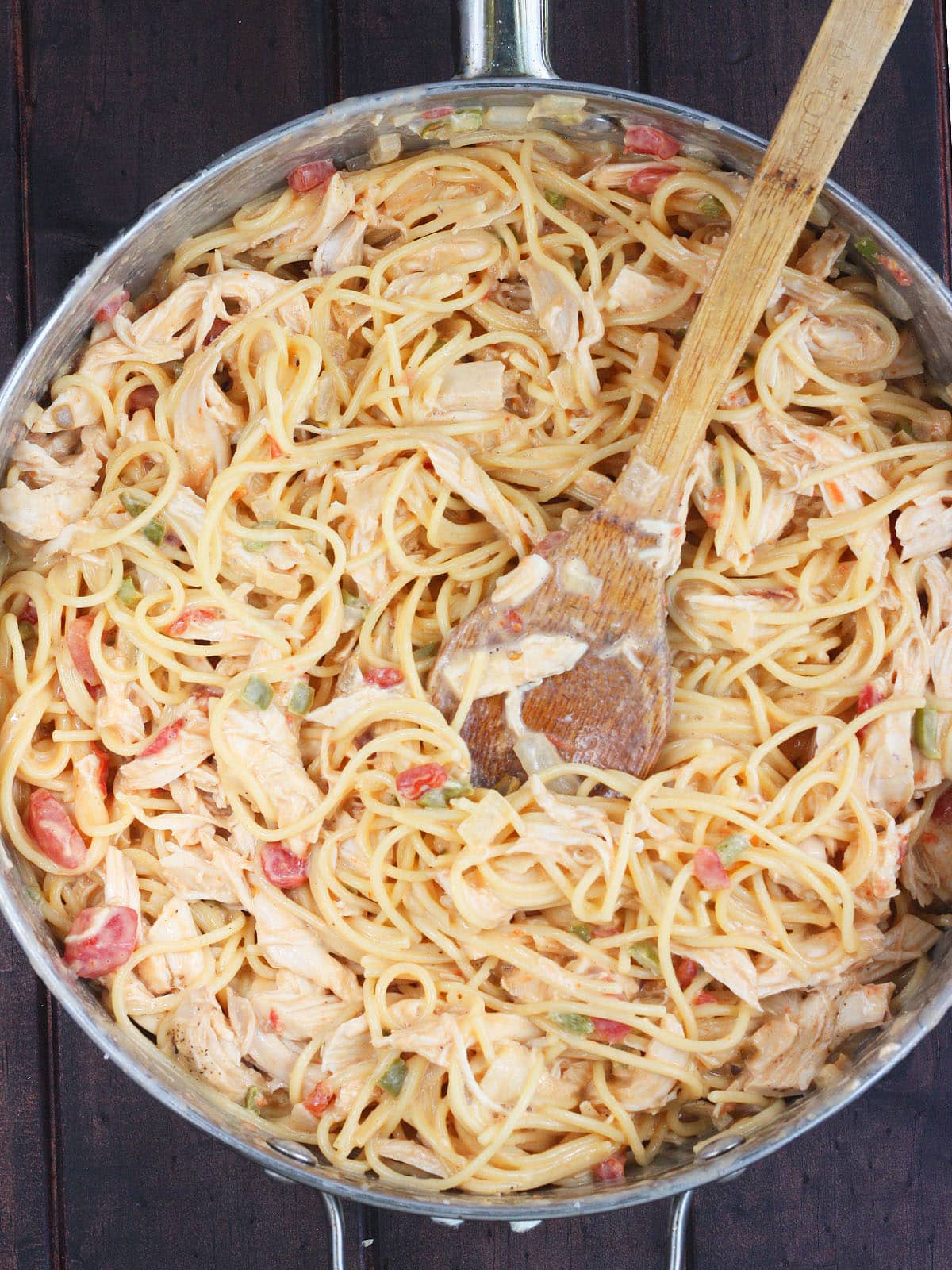 spaghetti noodles mixed with cheese, vegetables and rotel tomatoes in a large skillet