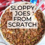 skillet of Sloppy Joes from scratch with a red and white checked napkin and buns to the side