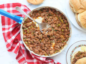 overhead shot of a skillet of Sloppy Joes with buns and a sandwich on the side