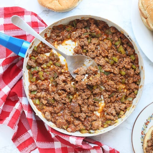 overhead shot of a skillet of Sloppy Joes with buns and a sandwich on the side