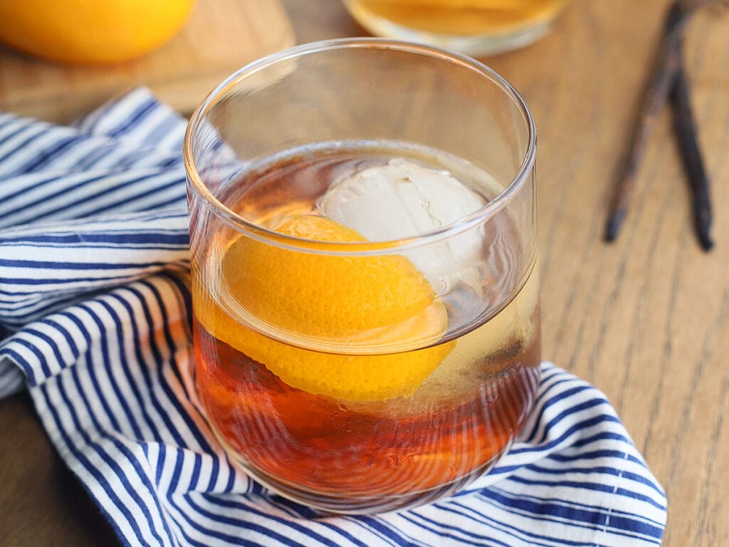 bourbon old fashioned cocktail on a blue and white napkin