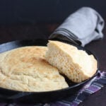 slice of cornmeal cut out and resting on top of a pan of cornbread
