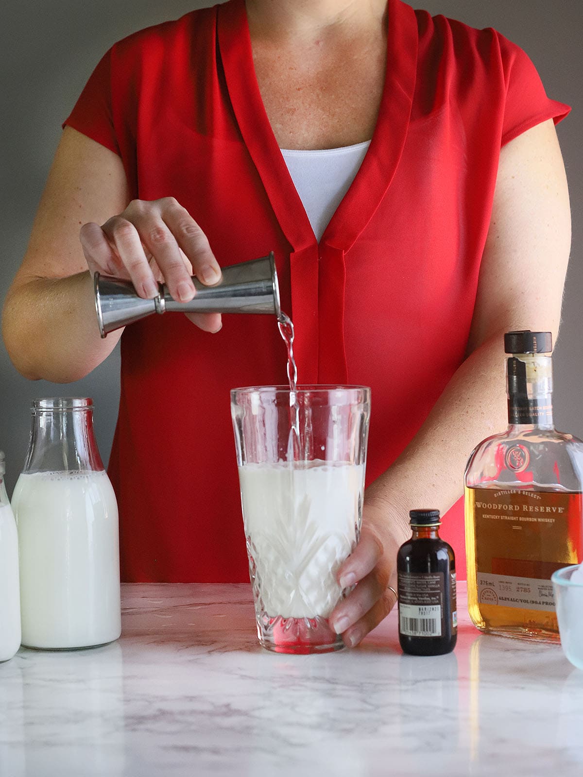 pouring simple syrup into a cocktail shaker