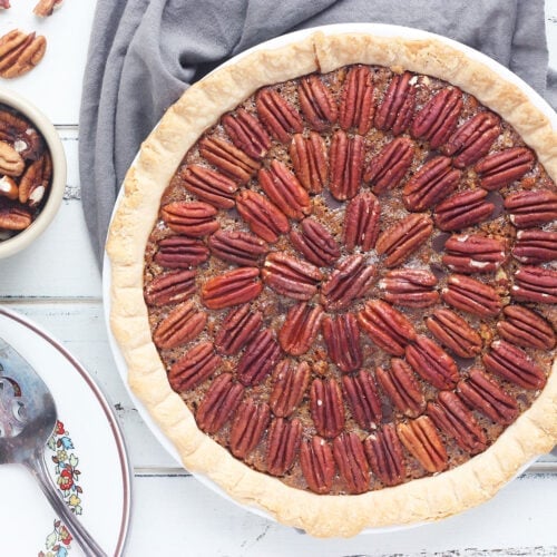 whole chocolate chip pecan pie on a gray napkin