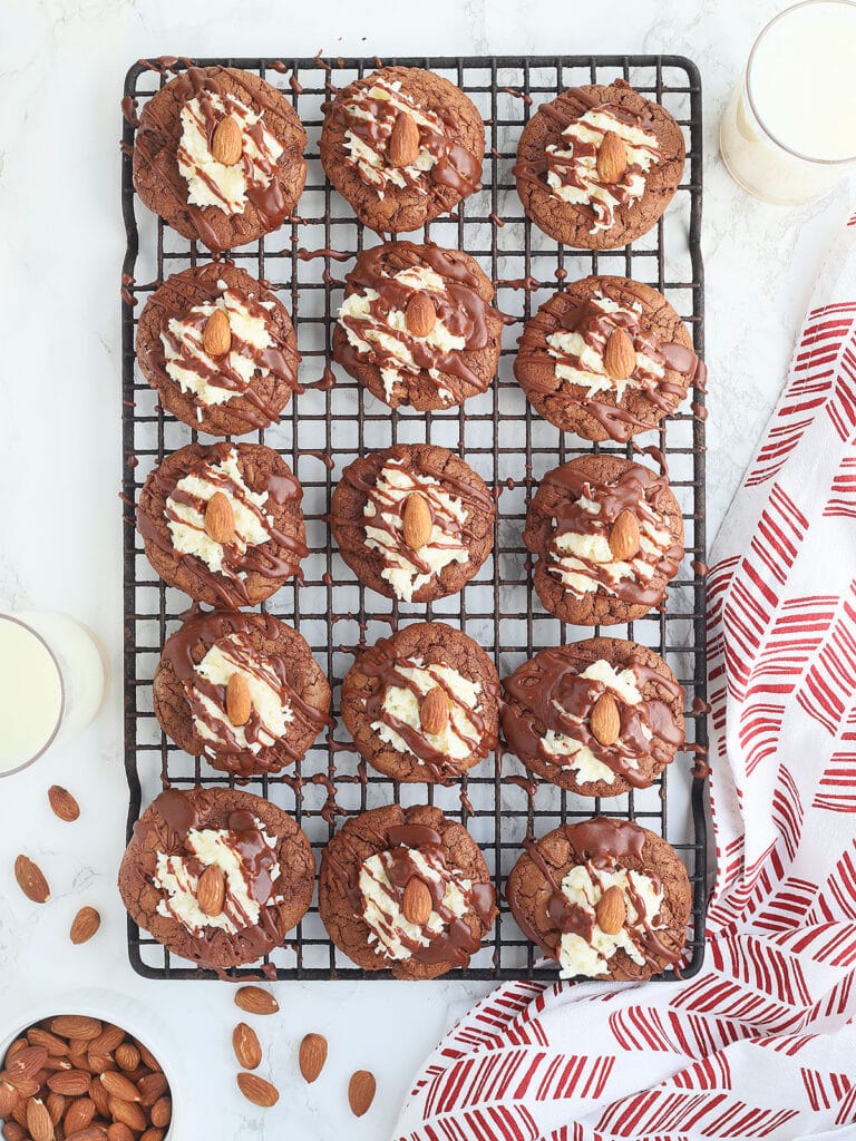 almond joy chocolate thumbprint cookies on a baking with a red and white napkin to the side