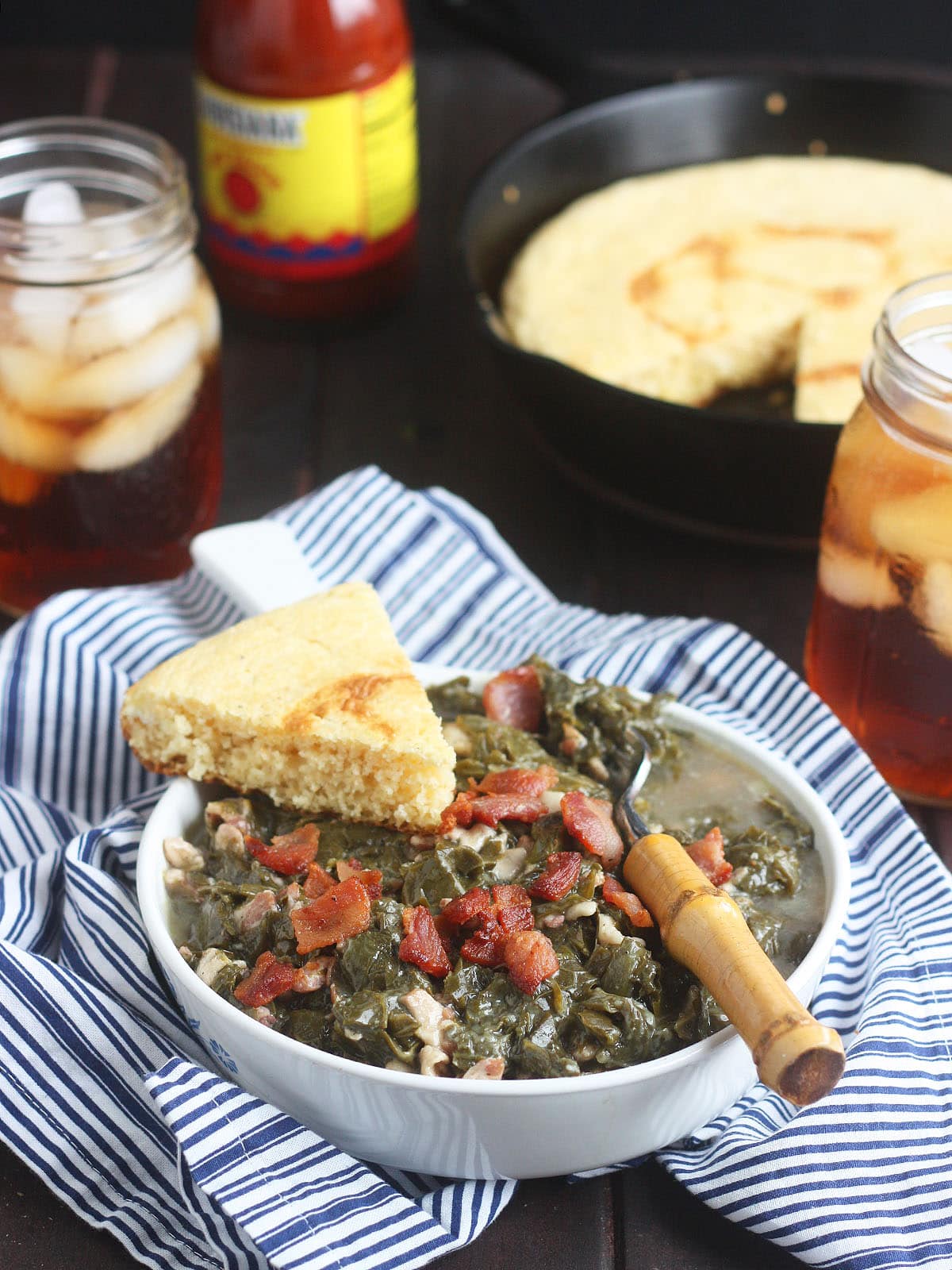 Turnip greens in a bowl with a wedge of cornbread on the side.
