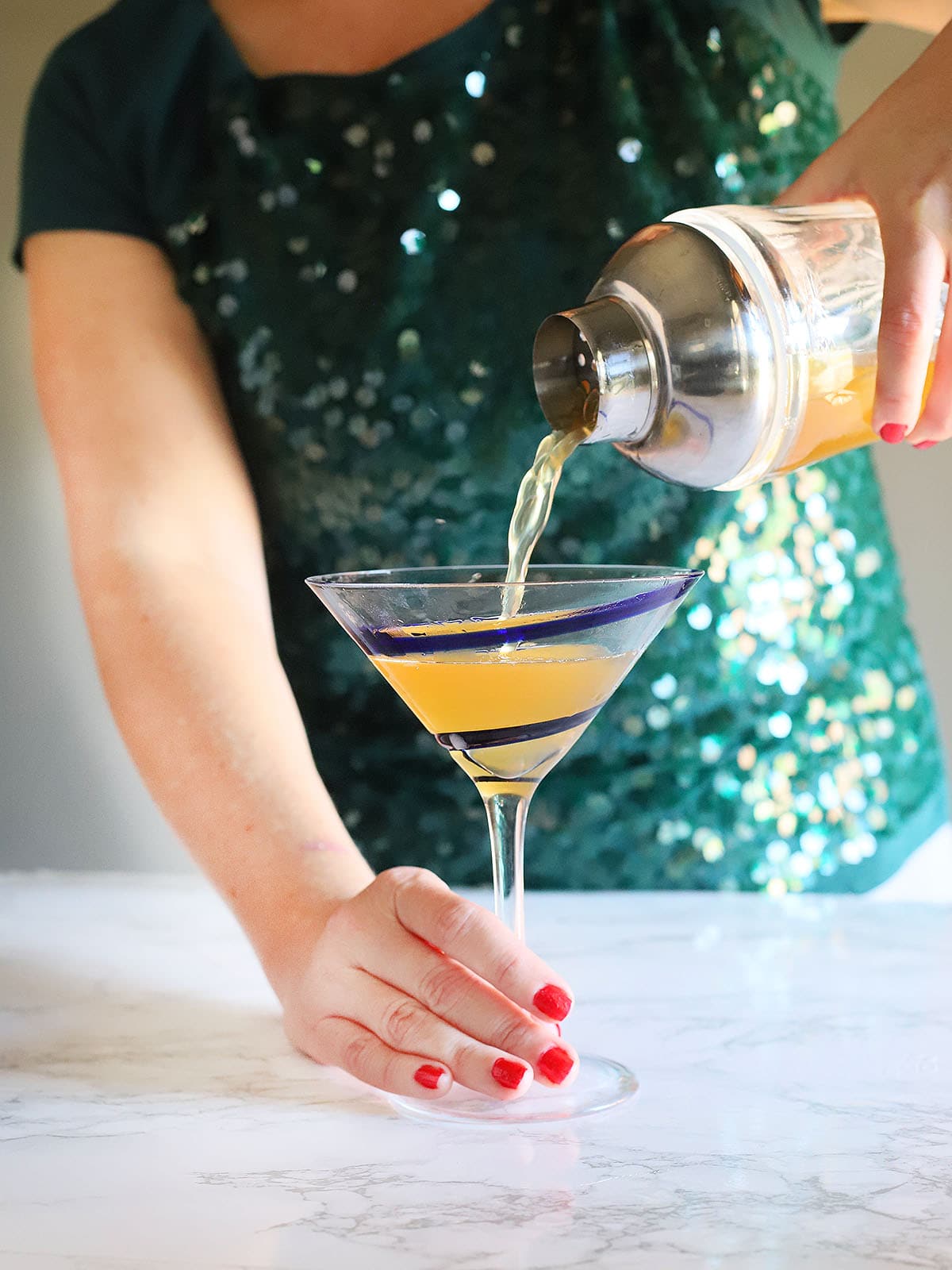 pouring the Tuaca pineapple martini into a martini glass
