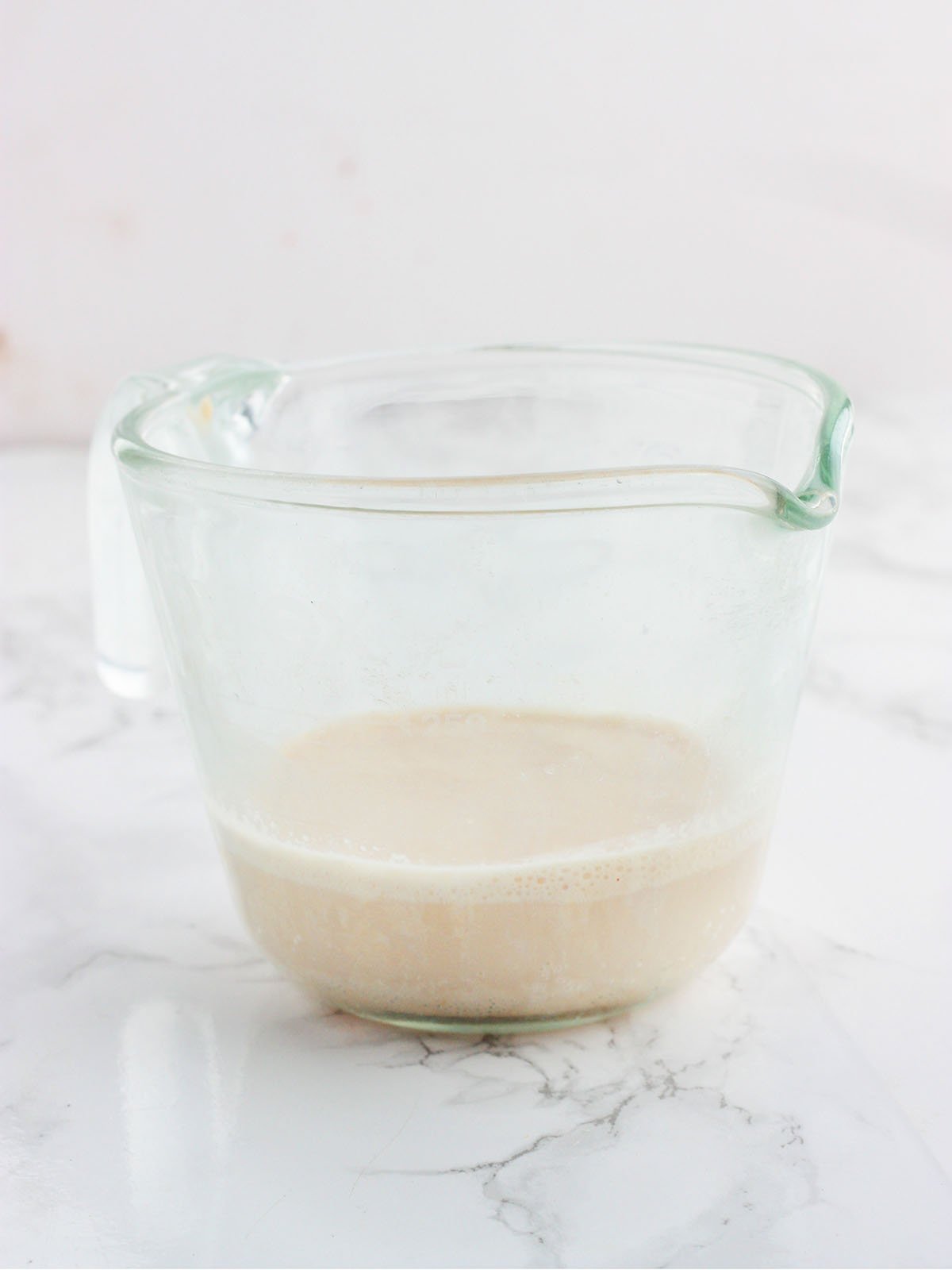 activated yeast with foam on top in a glass measuring cup
