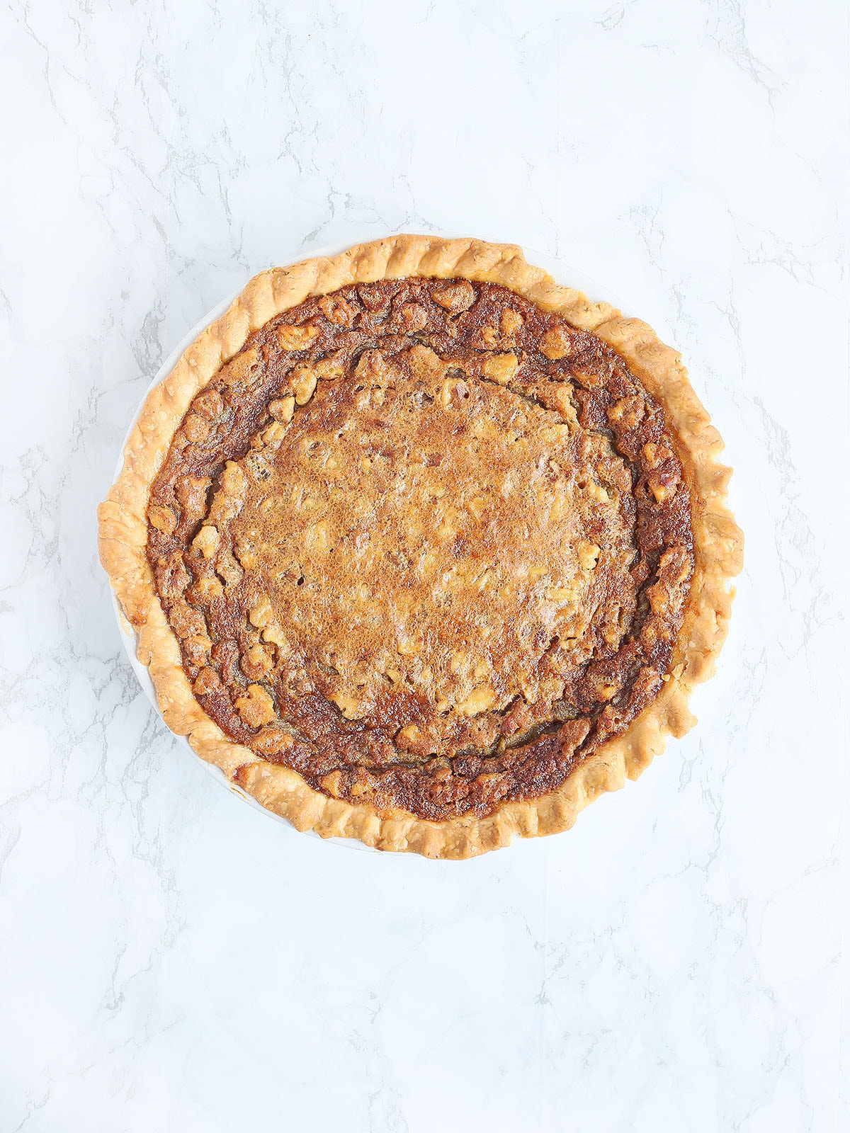 baked Kentucky Derby pie on a white marble background