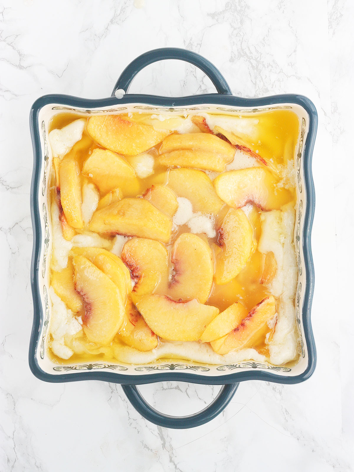 peach cobbler in a baking dish before going into the oven