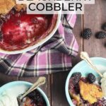 two blue bowls of blackberry cobbler with a scoop of vanilla ice cream. Serving dish of cobbler, a wooden serving spoon and fresh blackberries on the side
