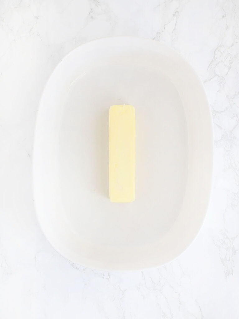 stick of butter in a white oval baking dish