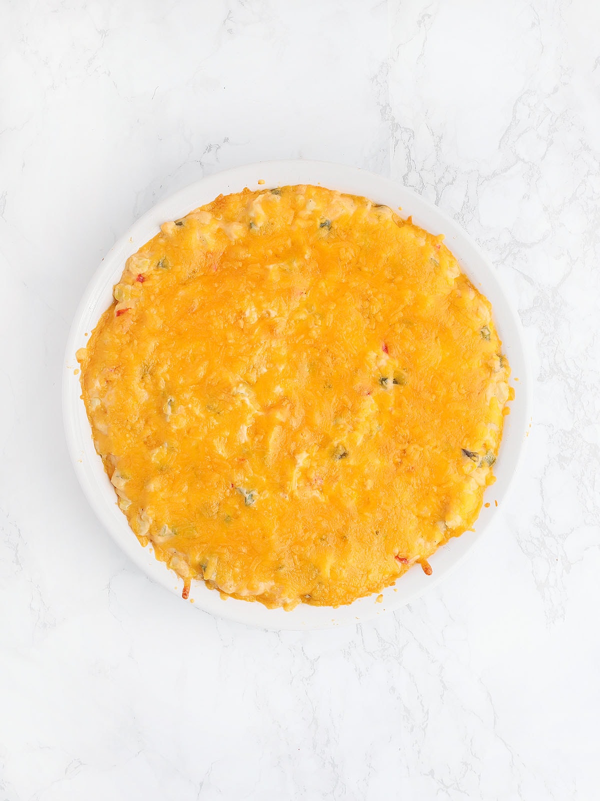 corn dip topped with melted cheese after it has been baked in the oven