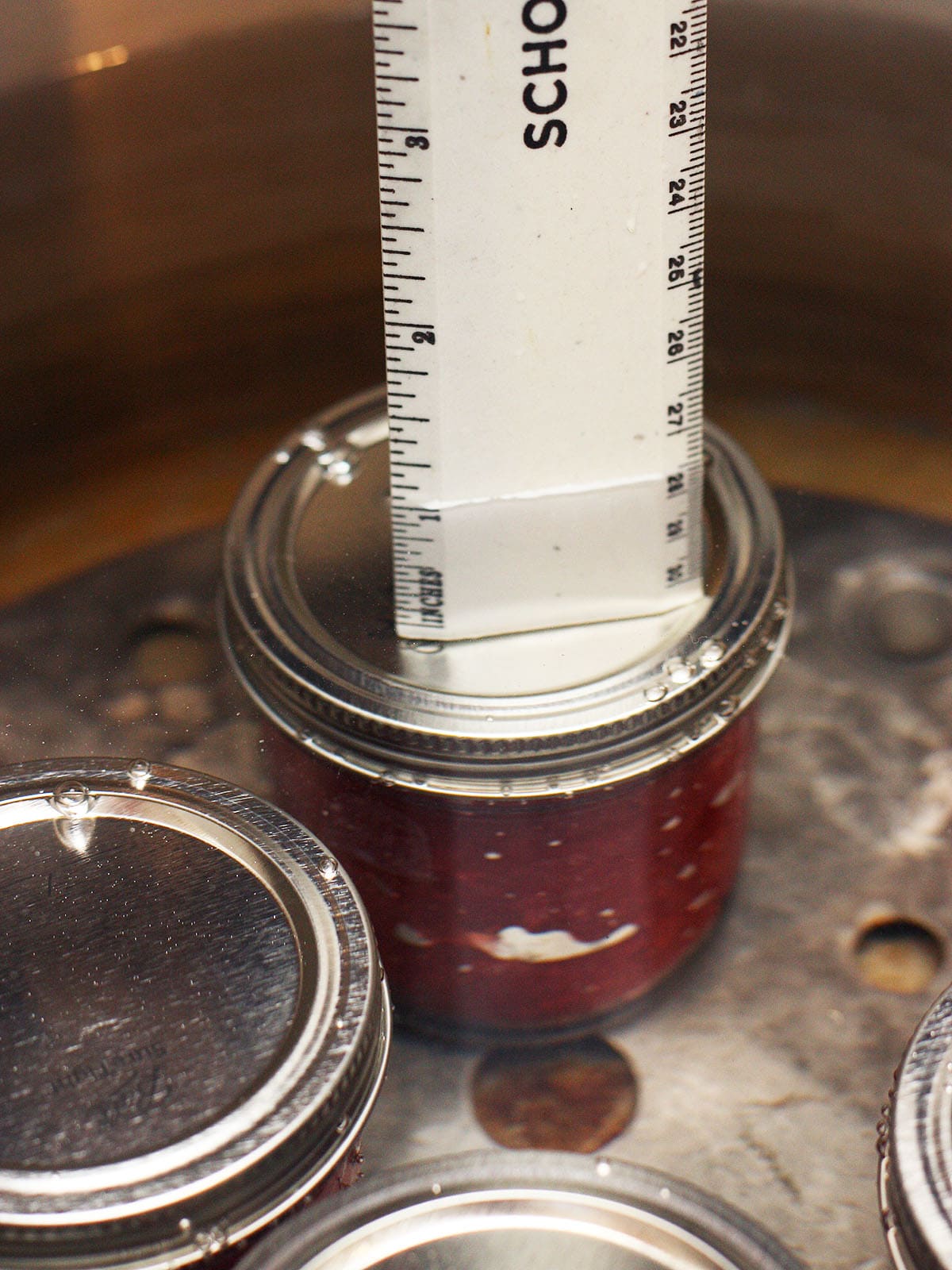 ruler showing the water level over the tops of the jars